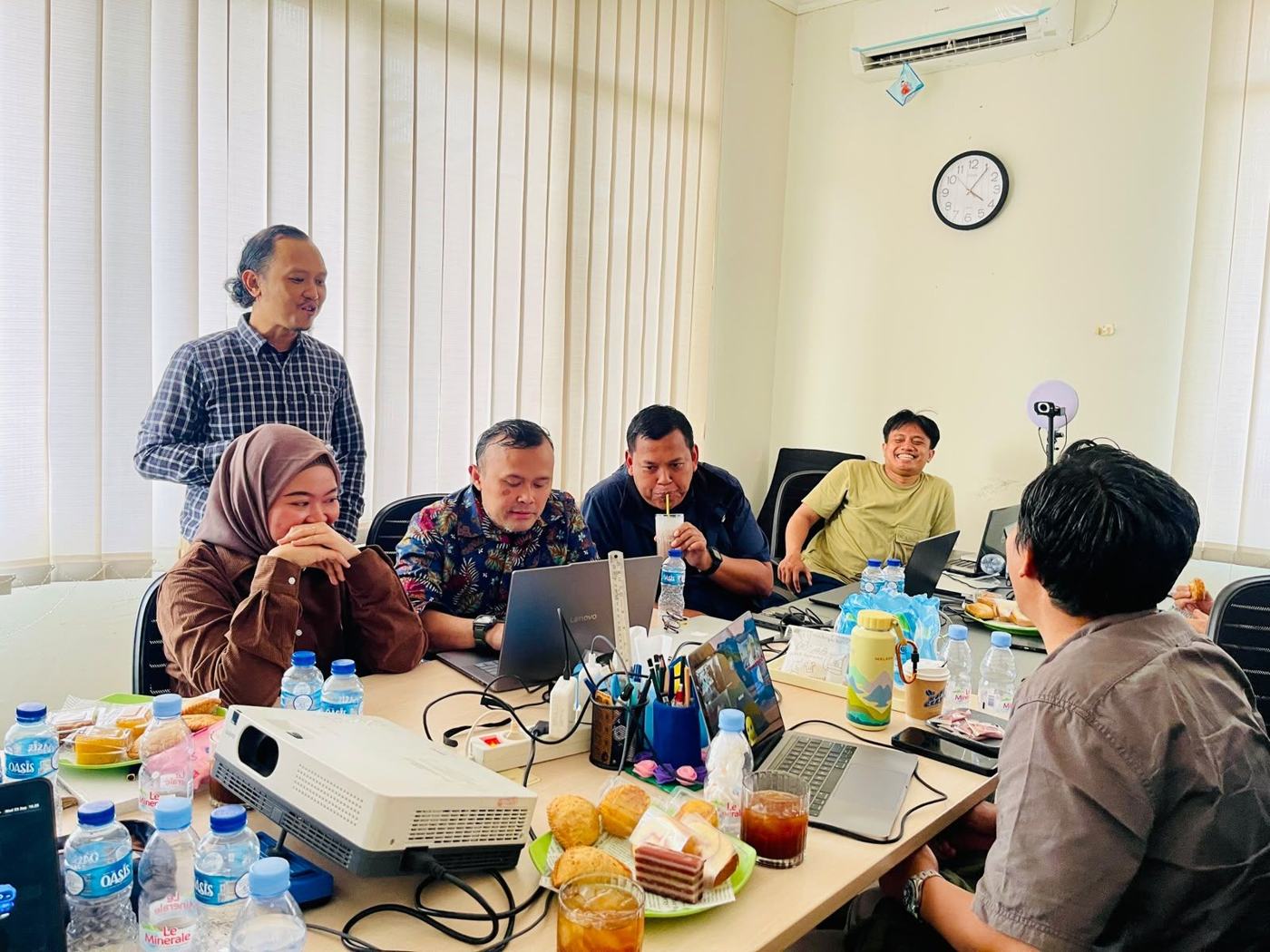 Trainer CERYA Foundation berdiskusi di sekitar meja dengan laptop dan proyektor selama Training of Trainers Intel SFI
